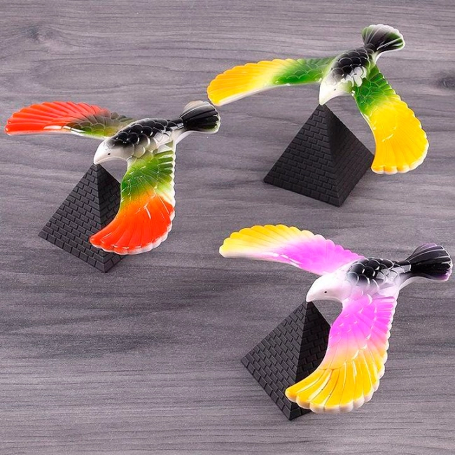 игрушка птица балансирует на клюве